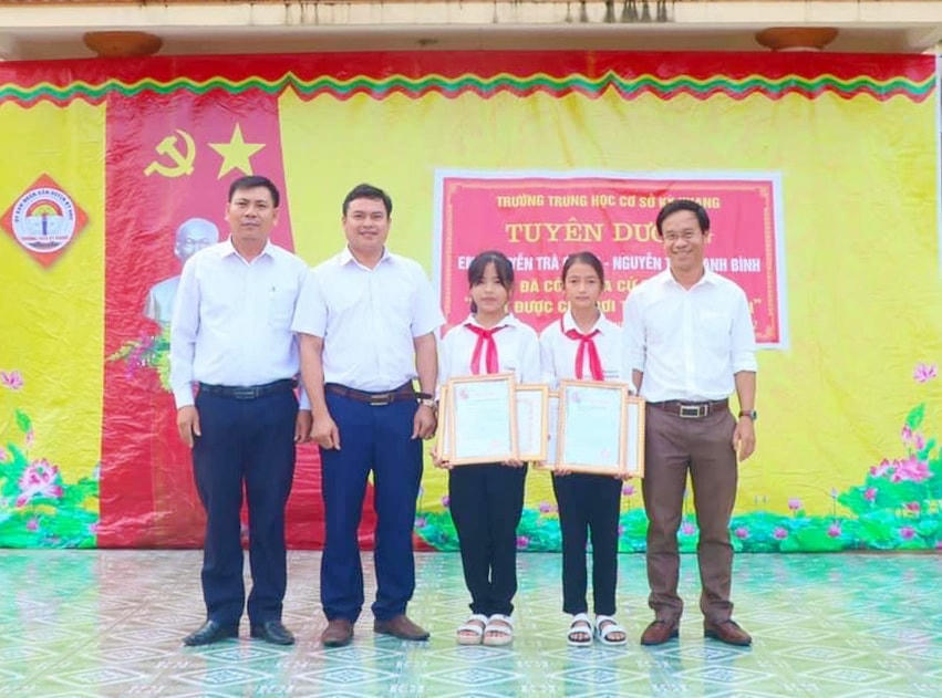 Ban giám hiệu trường THCS Kỳ Khang trao quà và khen thưởng hai em Nguyễn Thị Thanh Bình và Nguyễn Trà Giang.