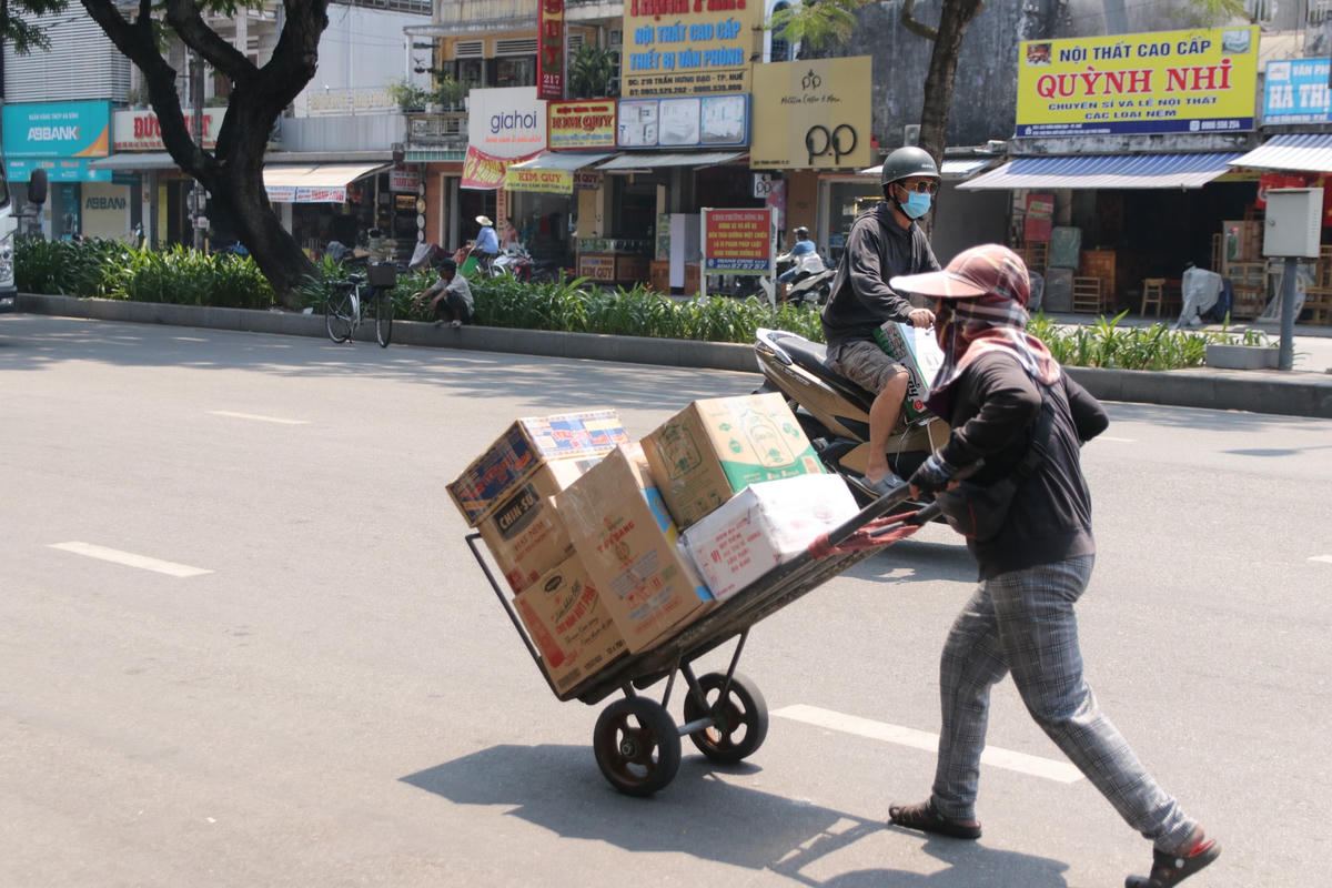 Dưới thời tiết nóng như thiêu đốt, những nữ cửu vạn tại chợ Đông Ba (thành phố Huế) vẫn miệt công việc mưu sinh của mình.