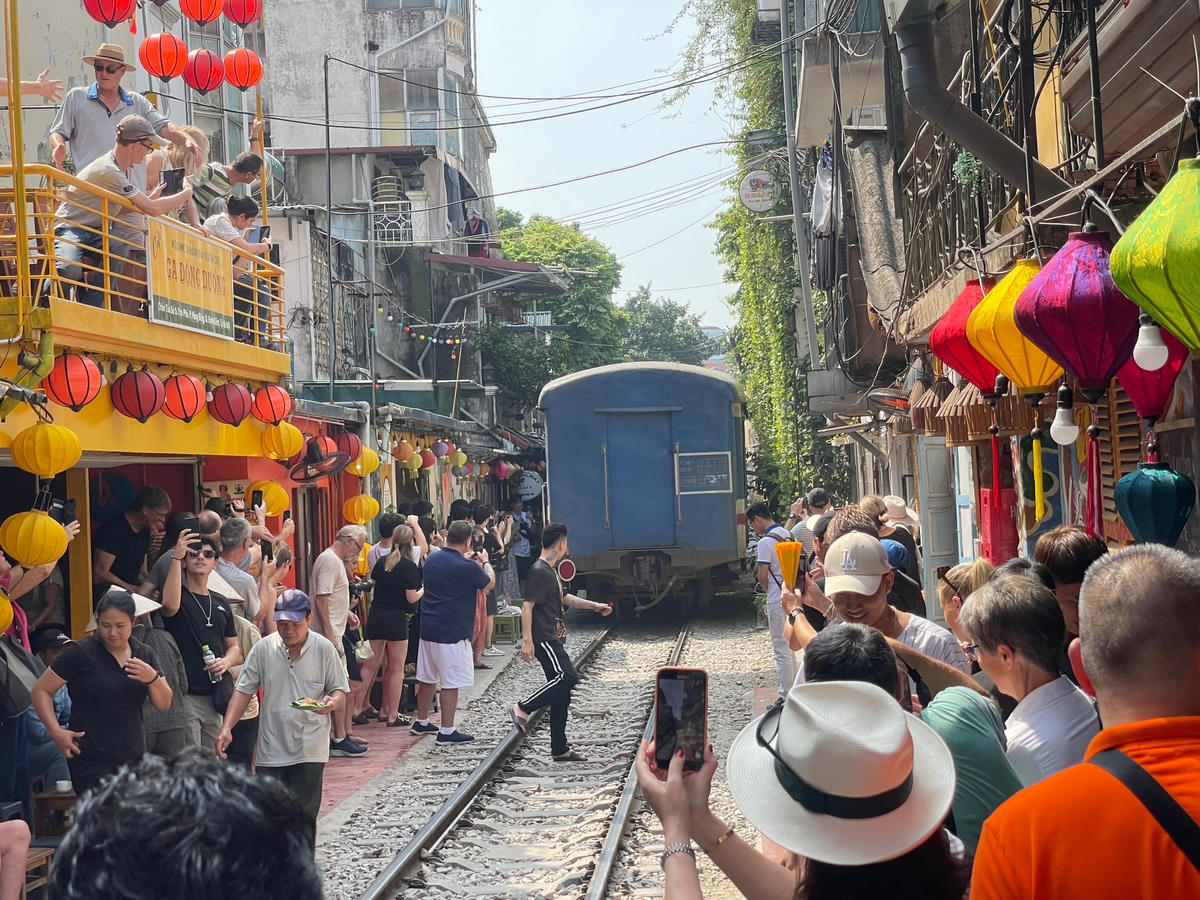 Du khách và người dân ùa ra chụp ảnh đoàn tàu tiềm ẩn nhiều nguy cơ mất ATGT.