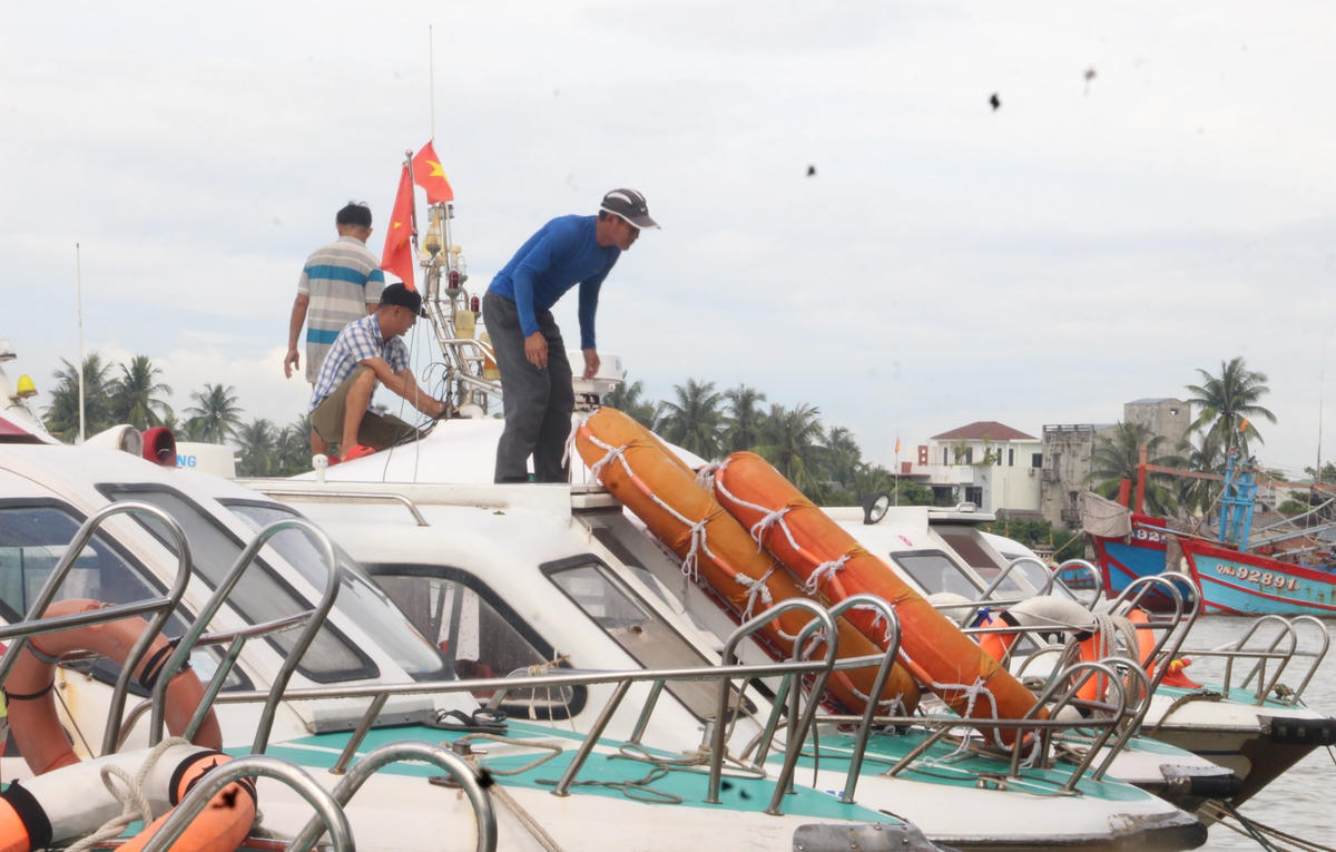 Người dân tháo các đồ đạc trên ca nô đem lên bờ.
