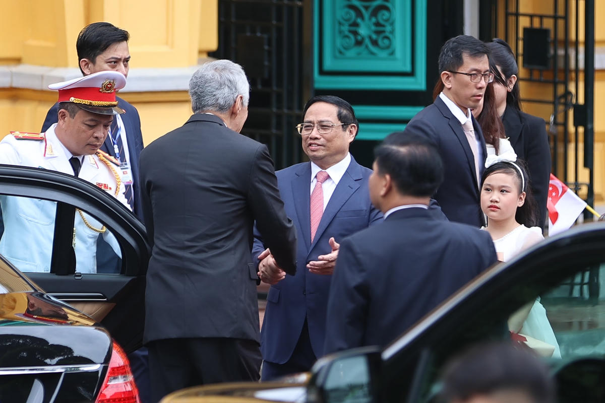 Thủ tướng Phạm Minh Chính đón Thủ tướng Singapore Lý Hiển Long tại xe. Ảnh: VGP/Nhật Bắc.