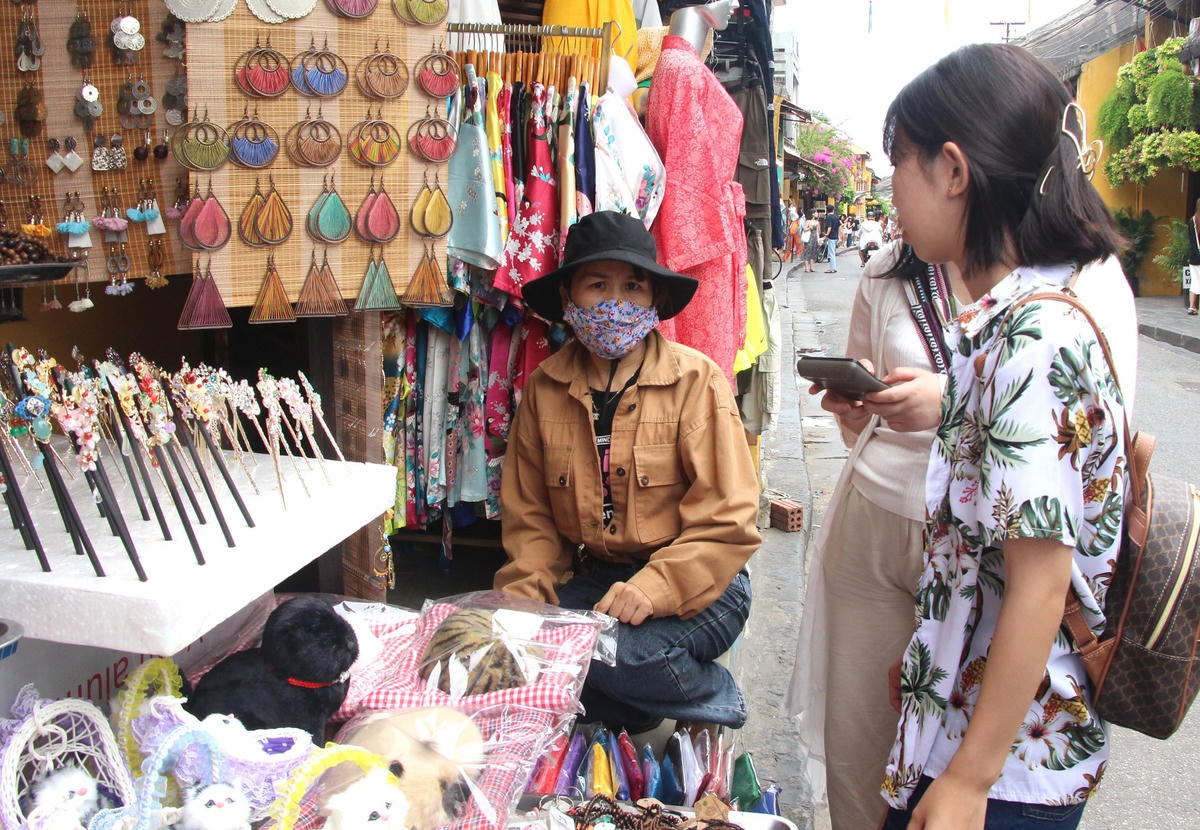 Du khách mua đồ lưu niệm.