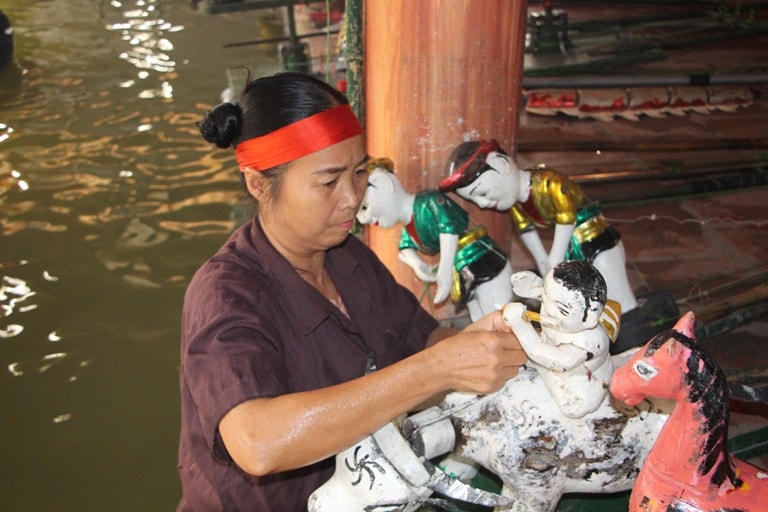 Nghệ nhân Nguyễn Thị Lan tự tay chuẩn bị những con rối trước khi diễn.