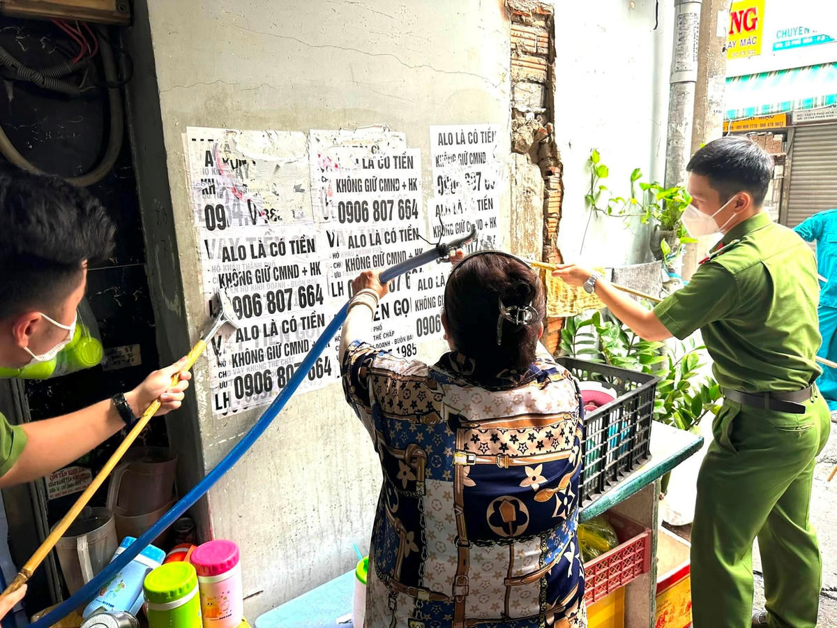 Công an quận Tân Bình, TP HCM hướng dẫn người dân tham gia tháo gỡ quảng cáo tín dụng đen bôi bẩn tại khu dân cư.