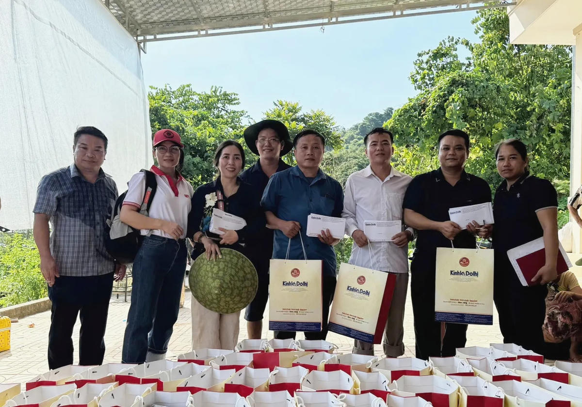 Thay mặt 53 hộ dân, Bí thư Chi bộ bản Phá Kháo Thò Pa Lư (áo xanh đứng giữa) nhận quà của Báo Kinh tế & Đô thị cùng các nhà hảo tâm.