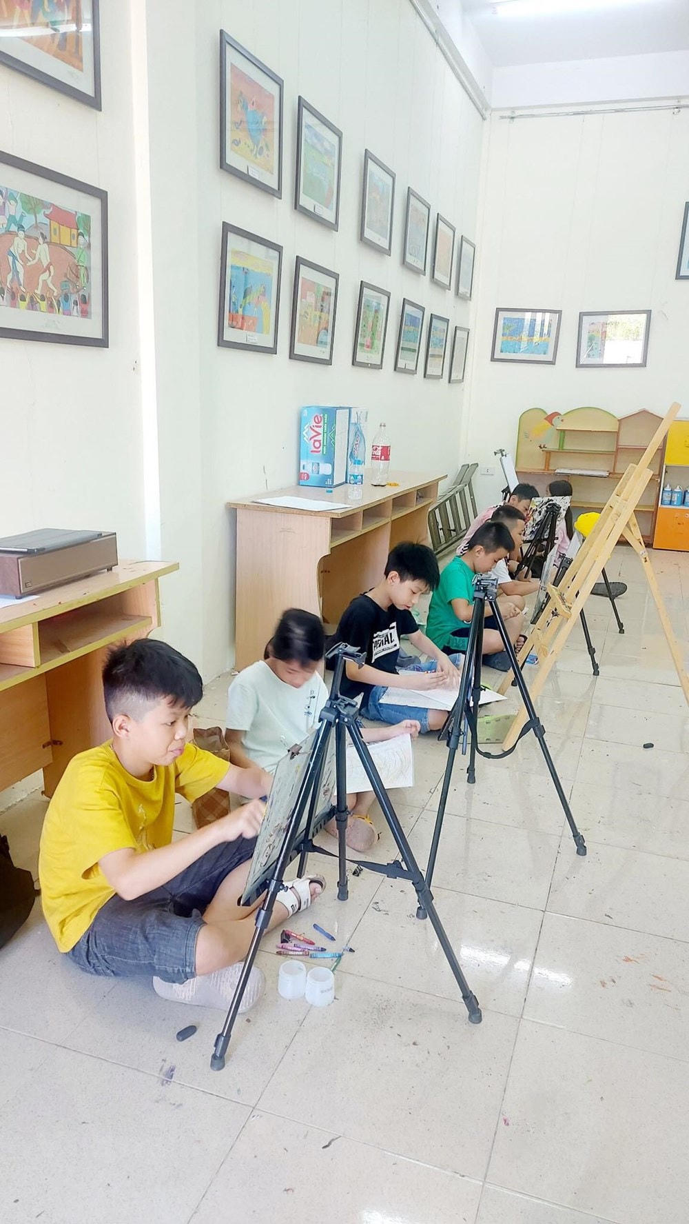 Các em thiếu nhi say sưa bên giá vẽ. (Nguồn: Vietnam+).