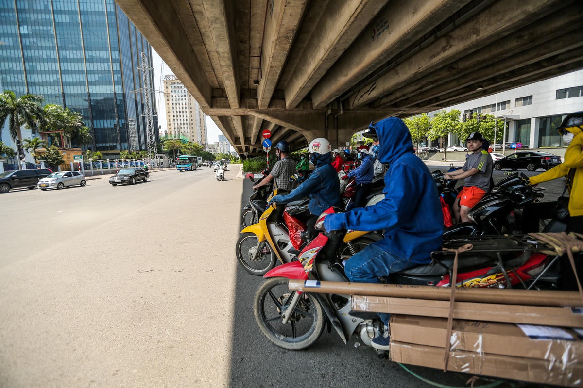 Người đi đường chờ đèn đỏ trong thời tiết nắng nóng tại Hà Nội. Ảnh: Lê Khánh.