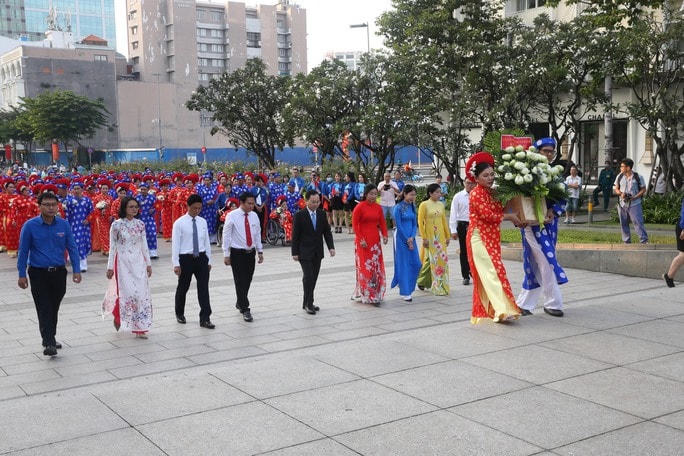 Cô dâu, chú rể dâng hoa tại Tượng đài Bác Hồ. Ảnh: NLĐ.