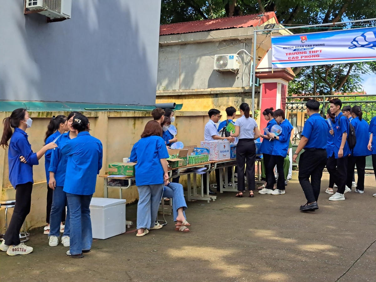 Các bạn đoàn viên tình nguyện chuẩn bị sữa bánh, nước lọc, quạt nhựa... cho các thí sinh tham gia dự thi tại Trường THPT Cao Phong.