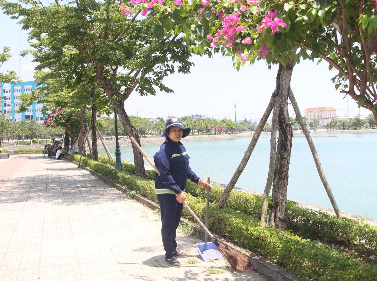 Cô Nguyễn Thị Hường quét rác ở bờ hồ Nguyễn Du.