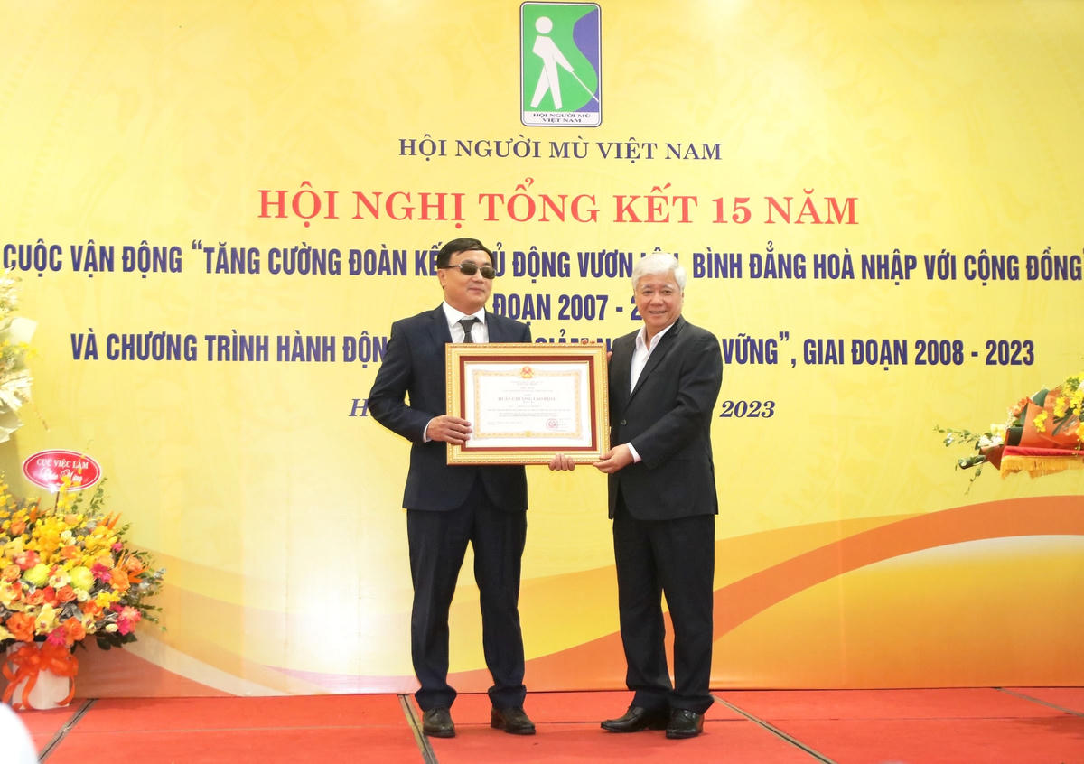 Chủ tịch Đỗ Văn Chiến trao Huân chương Lao động hạng ba cho ông Phạm Xuân Trường, Giám đốc Trung tâm Đào tạo cán bộ phục hồi chức năng cho người mù (Hội Người mù Việt Nam).
