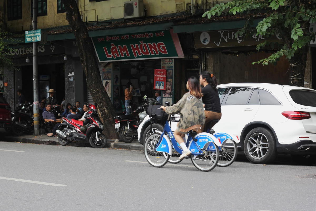 Dong xe trên con đường rộng và vắng, nắng thu loé lên sau những tán cây cổ thụ, tạo thành những tia nắng đẹp tựa như bầu trời đang "rót mật" khiến cho con người ta trở nên yêu mùa thu Hà Nội hơn bao giờ hết...