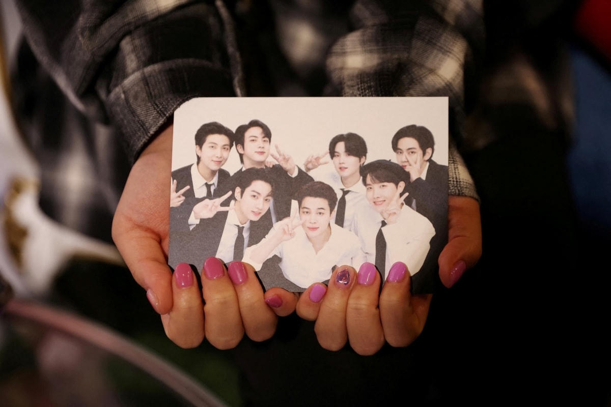 Một tấm ảnh của nhóm BTS trong tay người hâm mộ. Ảnh: Reuters.