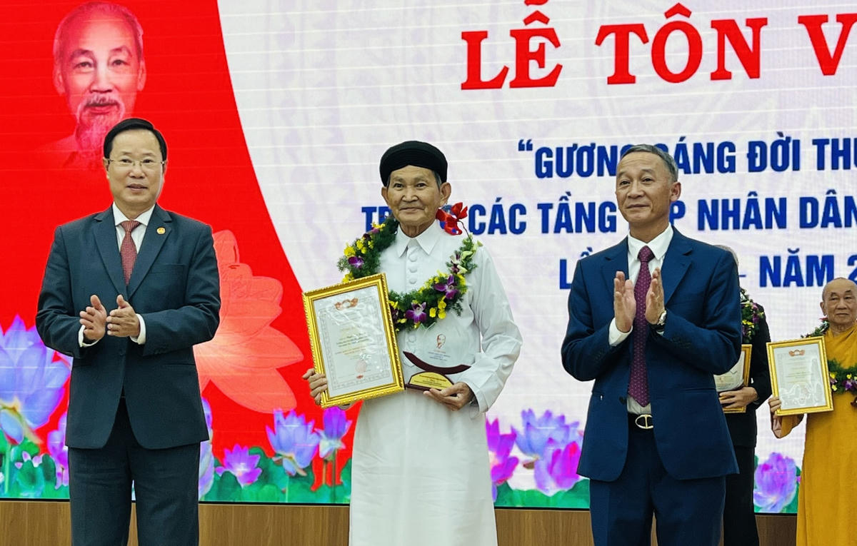 Chủ tịch UBND tỉnh Trần Văn Hiệp và Chủ tịch Ủy ban MTTQ Việt Nam tỉnh Phạm Triều tặng hoa, biểu trưng tôn vinh gương sáng đời thường.