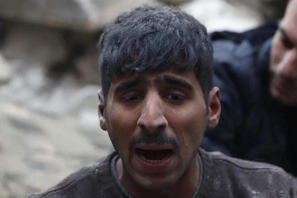 Phản ứng của một người đàn ông khi được các nhân viên Phòng vệ Dân sự Syria và lực lượng an ninh tìm thấy trong đống đổ nát của các tòa nhà bị sập, ở Aleppo, Syria. Ảnh: AP.