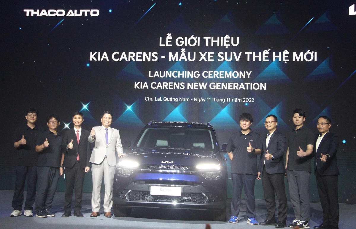 Các đại biểu chụp ảnh lưu niệm bên xe Kia Carens - mẫu xe SUV.
