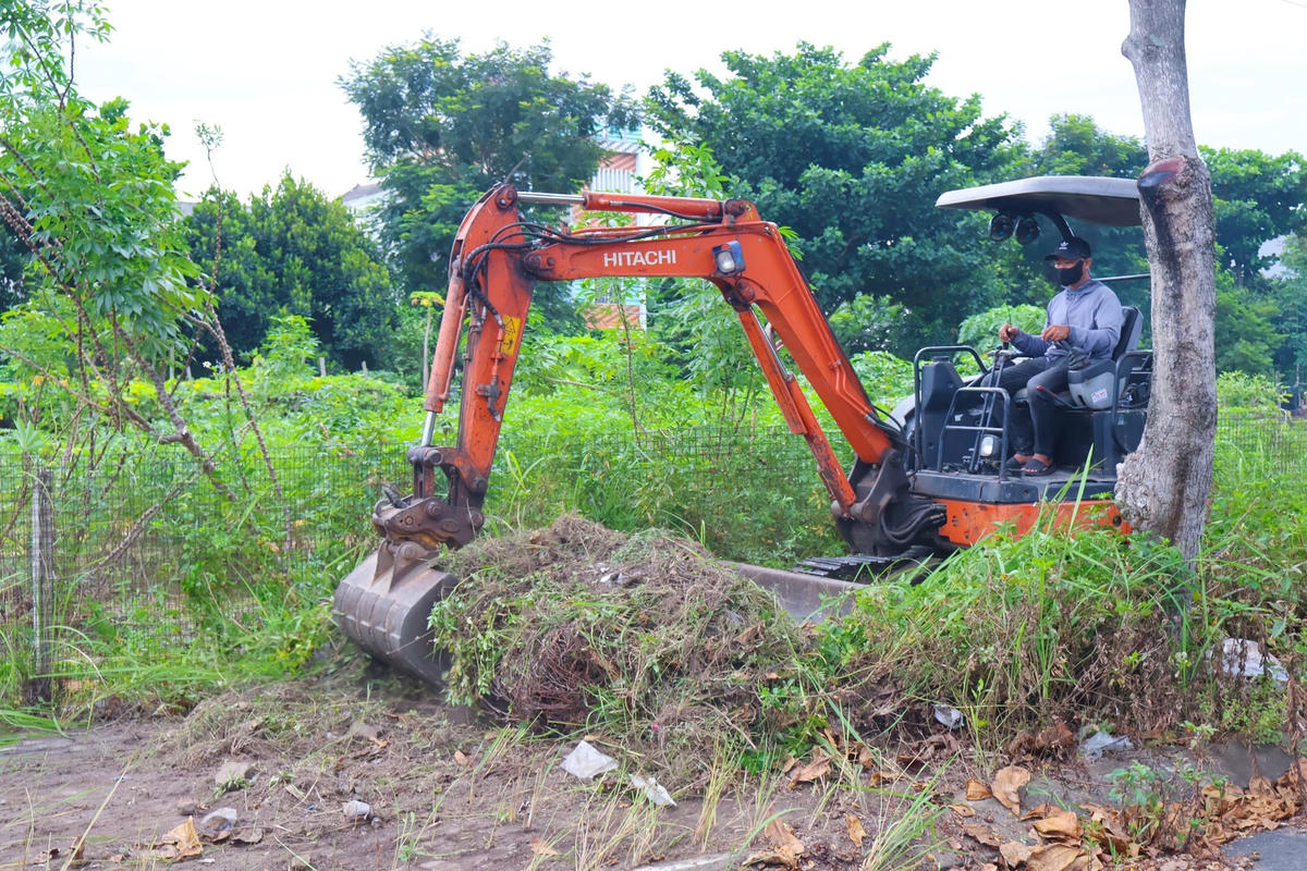 Huy động phương tiện phát quang, dọn cỏ để tạo lối thoát nước. Ảnh: Nguyễn Tú