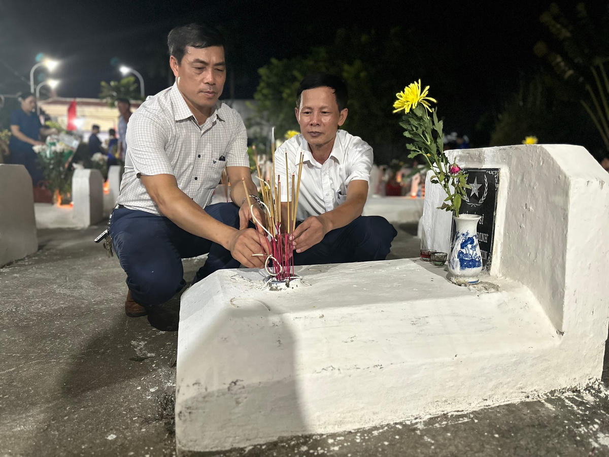 Ông Trần Văn Phấn, Bí thư Đảng ủy xã Đỗ Động (bên phải) và ông Nguyễn Bá Huy, Chủ tịch UBND xã Đỗ Động thắp hương phần mộ các anh hùng liệt sĩ.