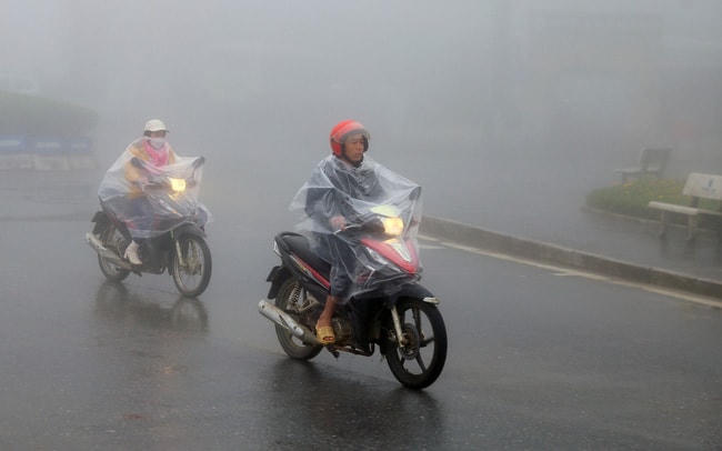 Người dân thị xã Sapa mặc áo mưa tránh rét. Ảnh: TTXVN.