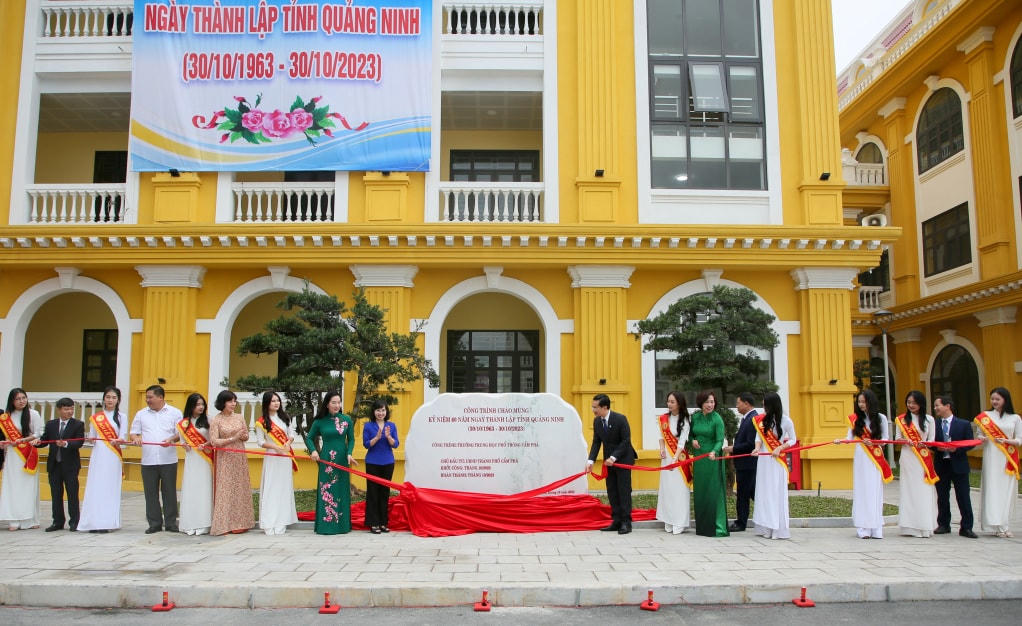 Các đại biểu thực hiện nghi thức gắn biển công trình chào mừng 60 năm Ngày thành lập tỉnh Quảng Ninh tại Trường THPT Cẩm Phả.
