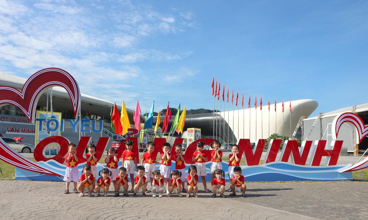 Các em nhỏ được cô giáo cho đi tham quan và chụp ảnh lưu niệm cùng biểu trưng “Tôi yêu Quảng Ninh”.