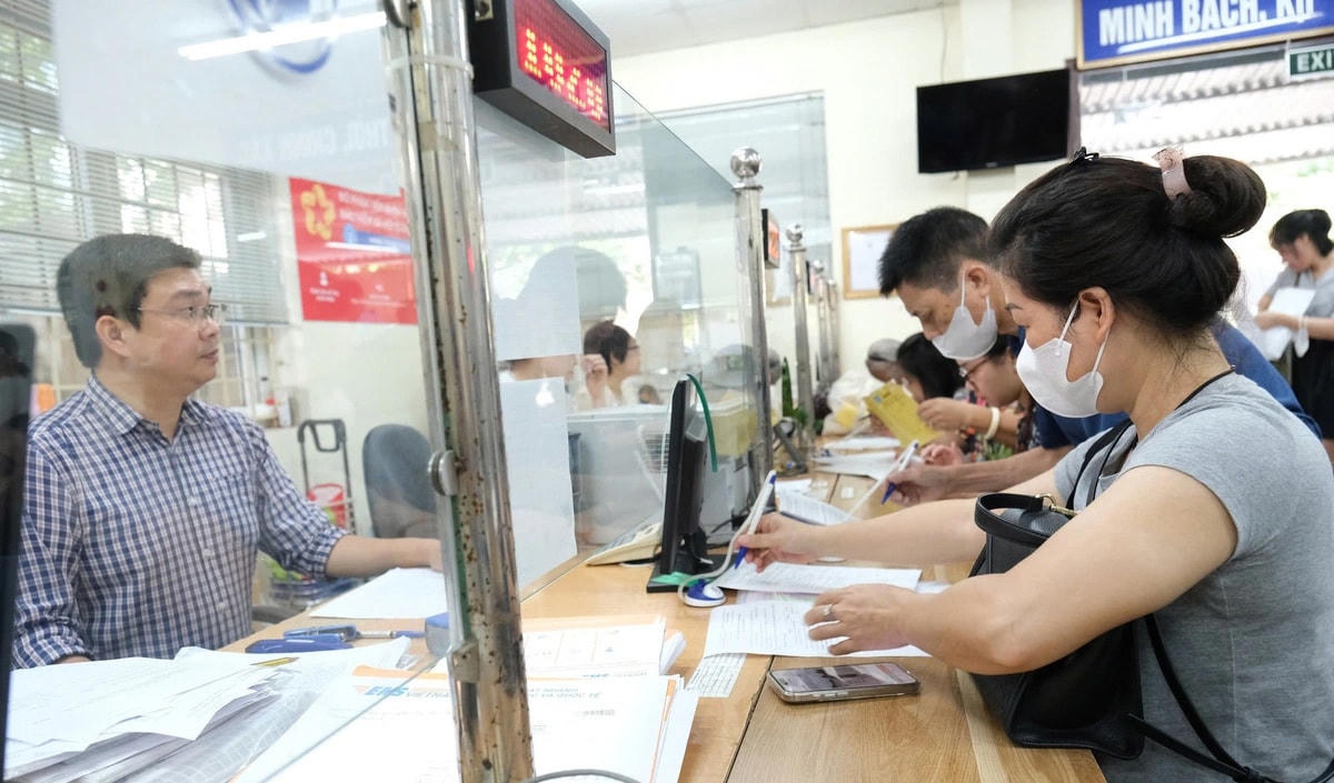 Cán bộ hướng dẫn người dân thực hiện thủ tục hành chính tại bộ phận một cửa của cơ quan nhà nước ở Hà Nội - Ảnh: HÀ QUÂN.