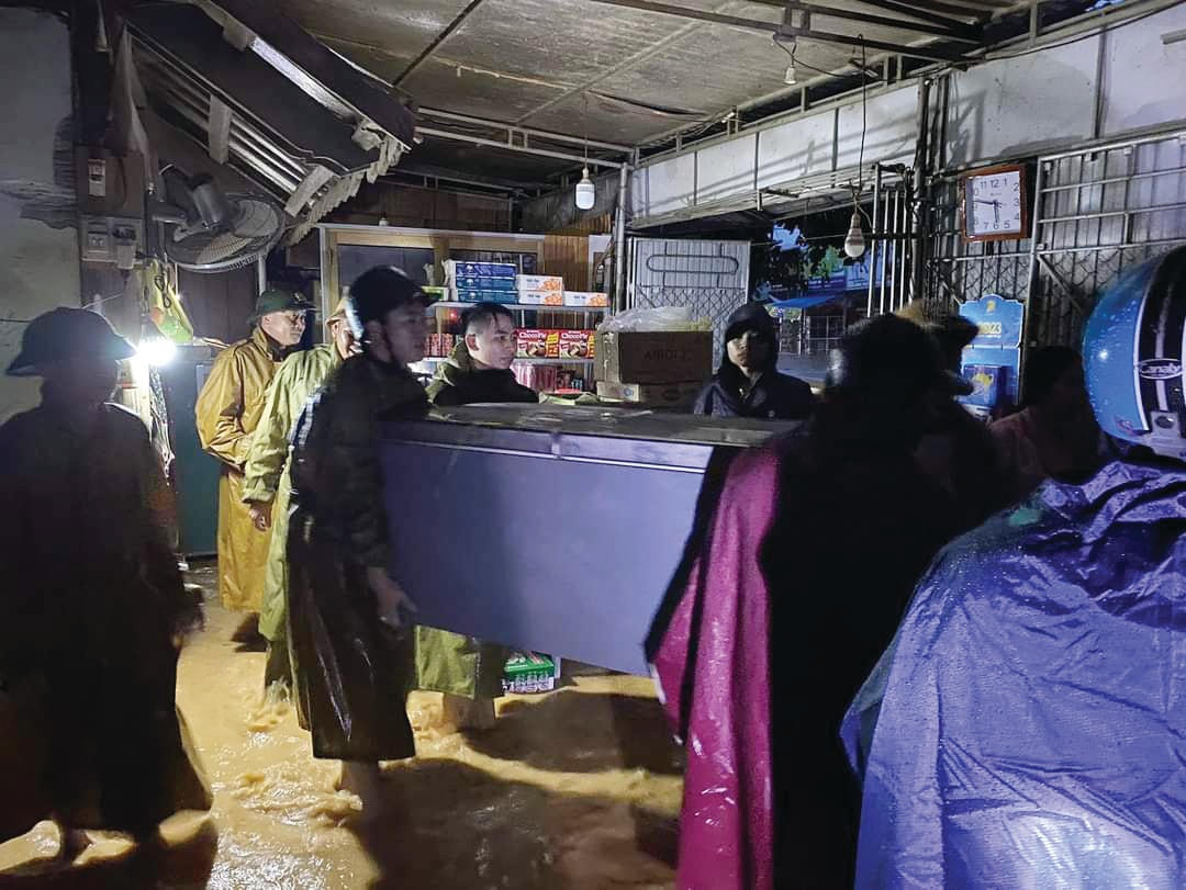 Mực nước lên nhanh khiến nhiều nhà dân bị ngập nước. Trong ảnh là người dân thị trấn Tân Lạc chạy lũ trong đêm.