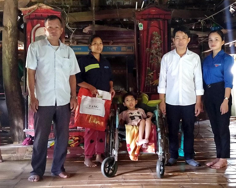 Ông Bùi Văn Hoàng (áo trắng thứ hai từ phải sang) tặng quà gia đình có hoàn cảnh khó khăn trên địa bàn xã Thượng Cốc (Hòa Bình).