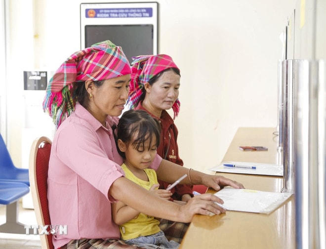 Đồng bào dân tộc Hà Nhì làm thủ tục tại Trung tâm phục vụ hành chính công xã biên giới Sín Thầu, tỉnh Điện Biên. (Ảnh: Trung Kiên/TTXVN) ttxvn-chinh-quyen-hai-cap-3.jpg