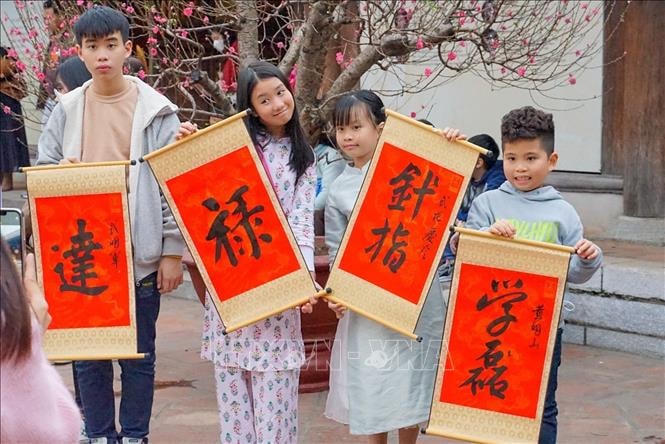Các em nhỏ thích thú khi xin được chữ ở Văn Miếu Quốc Tử Giám ngày 2 Tết Quý Mão.