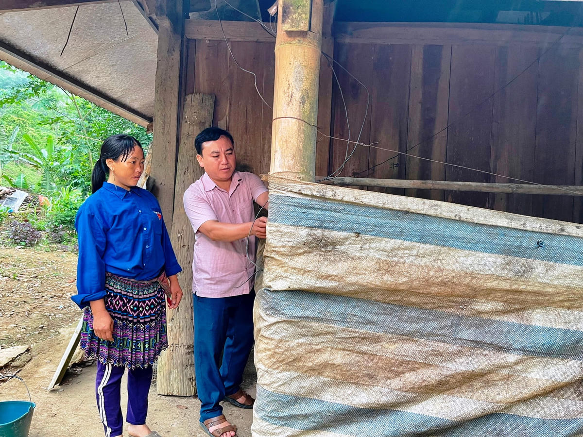 Chủ tịch MTTQ xã Trung Lý Sùng A Páo hướng dẫn người dân che chắn chuồng trại cho bầy gia súc trước khi mùa đông đến.