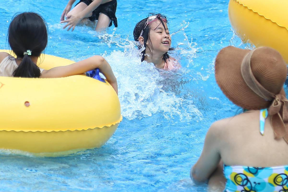 Trẻ em thích thú chơi đùa dưới làn nước mát, xua tan cái nóng oi bức.