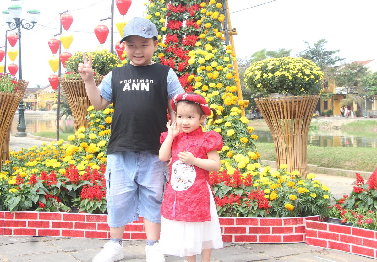 Nhiều em nhỏ chụp ảnh bên bờ sông Hoài.