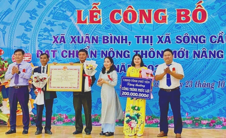Trao bằng công nhận xã đạt chuẩn nông thôn mới nâng cao và tiền thưởng để thực hiện công trình phúc lợi tại địa phương.