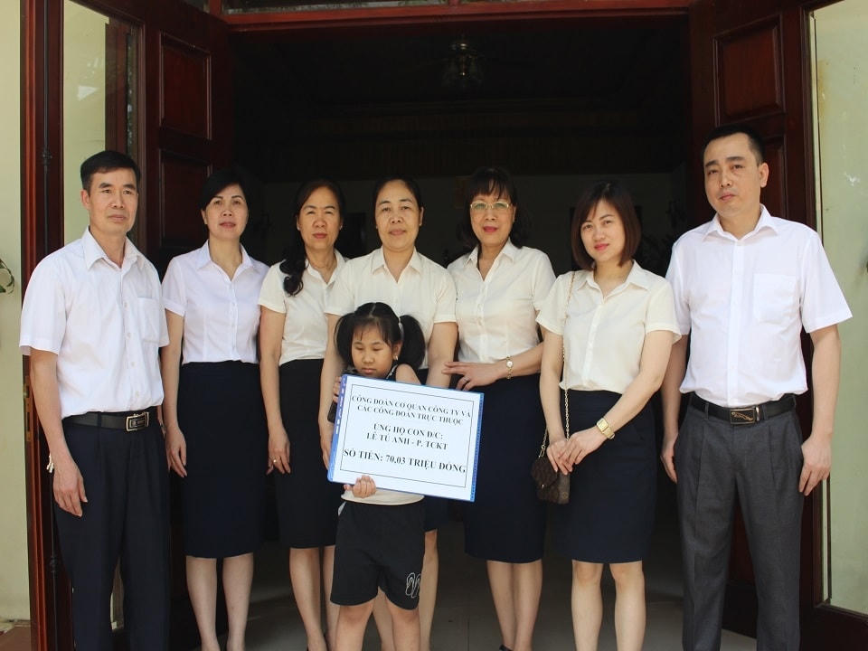 Chị Phạm Hồng Hà - Kế toán trưởng Công ty Điện lực Lạng Sơn (Đứng thứ 3 từ trái sang) đến thăm và trao tặng quà cho con của nữ công nhân viên công tác tại phòng Tài chính kế toán ốm đau.