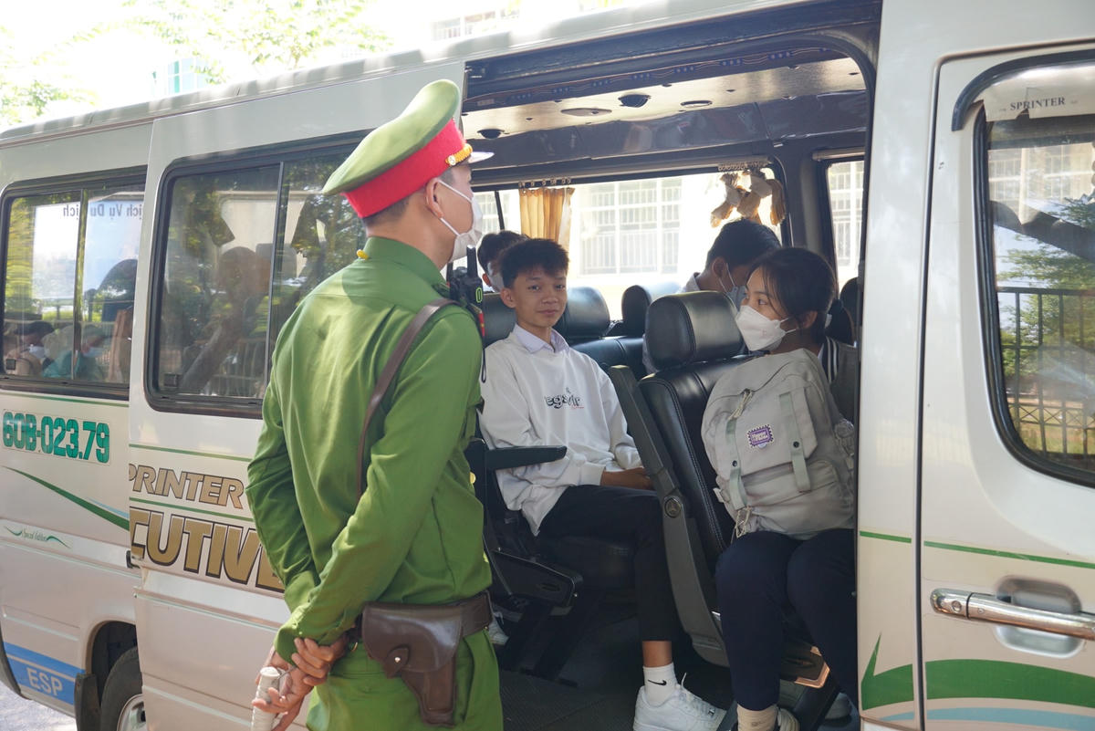 Lực lượng chức năng động viên các em học sinh trong quá trình chờ đợi thực hiện kiểm tra đối với người điều khiển phương tiện. Ảnh: Mạnh Thìn.