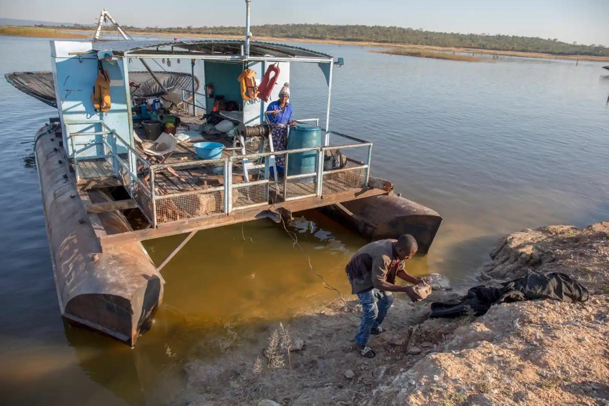Thuyền trưởng Siyakanyowa neo thuyền phao ở một cửa vào của hồ gần làng Simatelele, trong khi Esnath Munkuli trông coi. Ảnh: The Guardian.