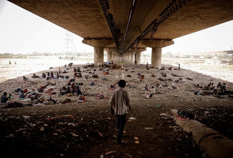 Mọi người ngủ trên lòng sông Yamuna, dưới một cây cầu vào một ngày hè nóng nực ở New Delhi, Ấn Độ.