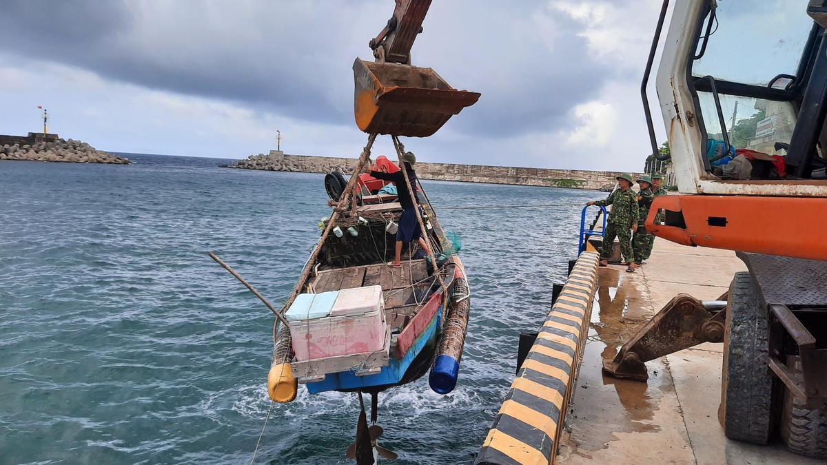 Lực lượng chức năng tỉnh Quảng Trị hỗ trợ người dân chuẩn bị ứng phó với bão số 4. Ảnh: Nghĩa Văn.