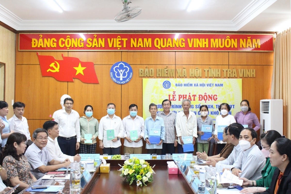 Phó Chủ tịch UBND tỉnh Lê Thanh Bình (đứng giữa) và Giám đốc BHXH tỉnh Bùi Quang Huy (bìa trái) trao sổ BHXH tự nguyện, thẻ BHYT cho người dân.