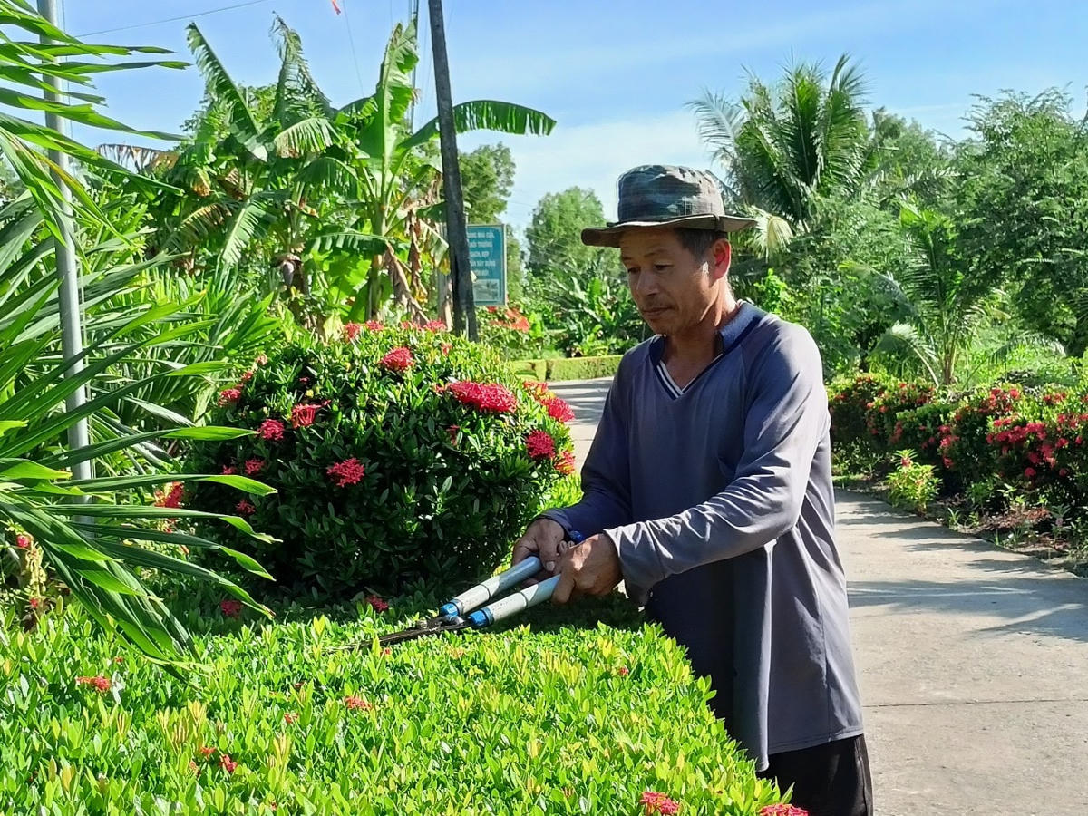 Người dân cắt tỉa đường hoa, tạo cảnh quan xanh - sạch - đẹp.