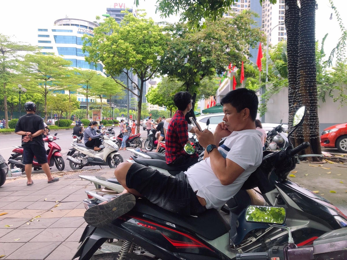 Một số phụ huynh ngồi chờ trên xe.
