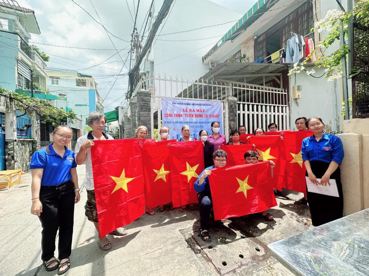 Đông đảo bạn trẻ, đoàn viên, thanh niên chụp ảnh cùng cờ Tổ quốc trong ngày ra mắt "Tuyến đường cờ Tổ quốc" của Quận đoàn quận 4 và Ban Tuyên giáo Quận ủy quận 4 (TP HCM). 