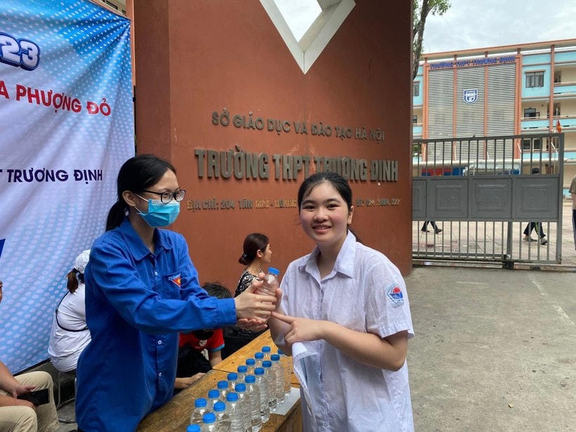 Thanh niên tình nguyện phát nước cho thí sinh trước cổng trường.  
