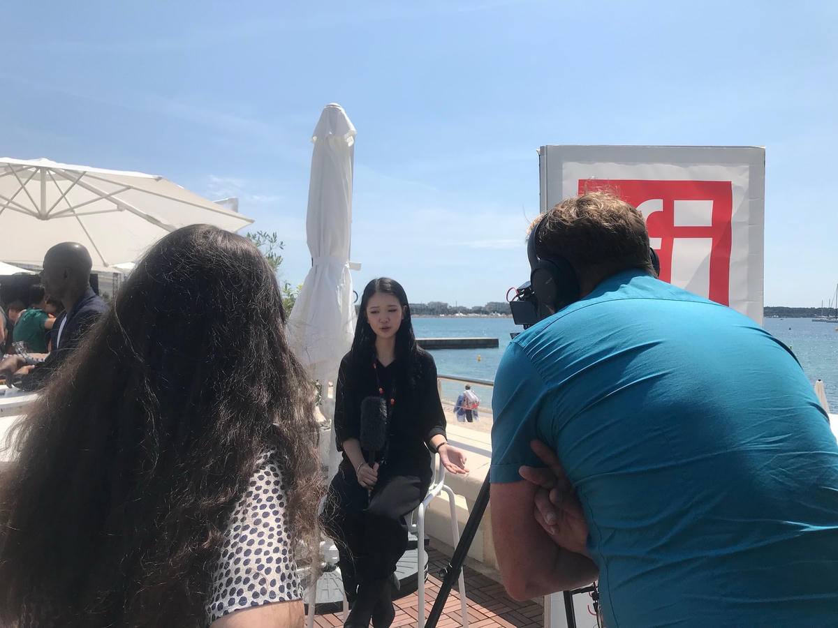 Linh Đan trả lời phỏng vấn đài RFI trên bờ biển Cannes. 