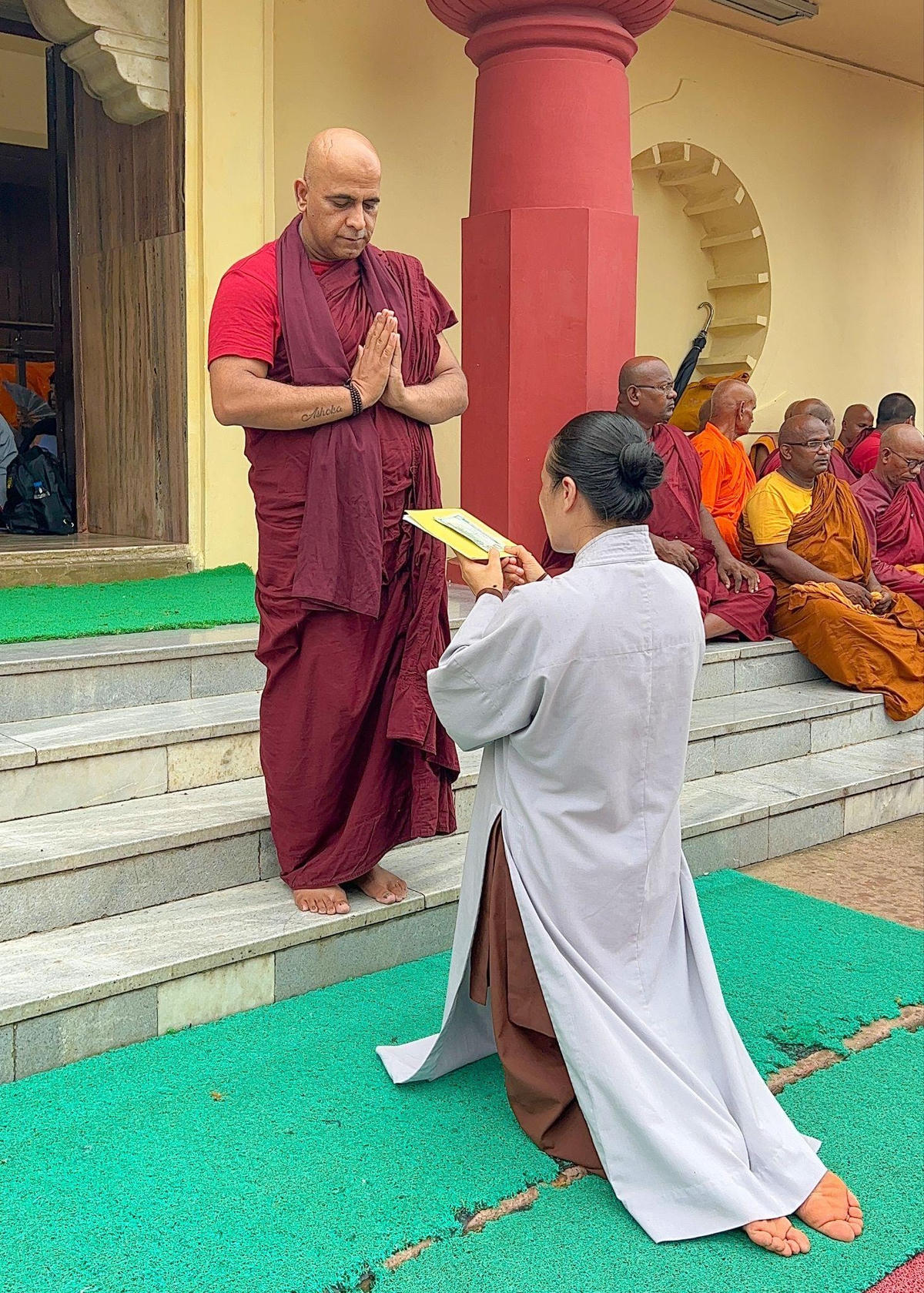 Phật tử Phạm Thị Yến, chủ nhiệm câu lạc bộ Cúc Vàng (chùa Ba Vàng) cúng dường chư Tăng tại đền Đại Niết Bàn.