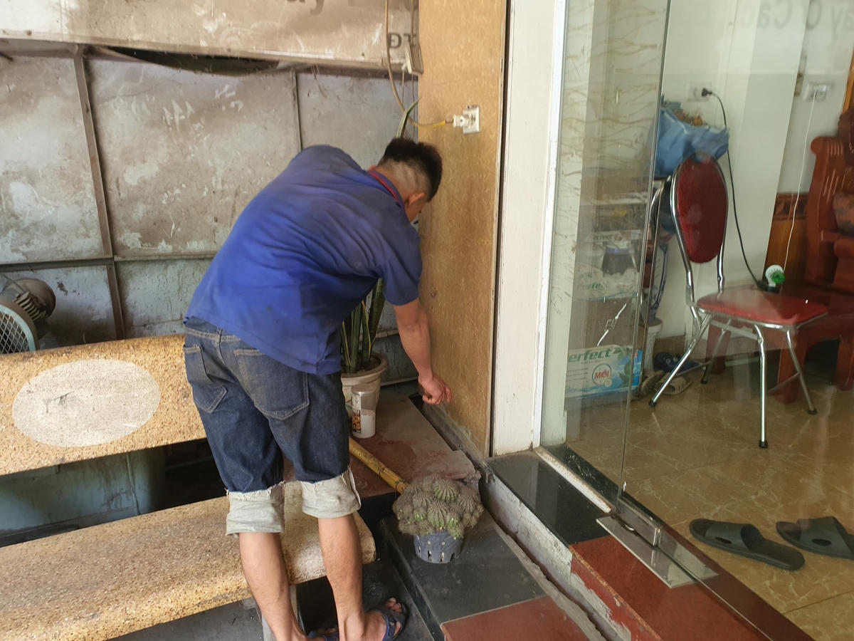 Nhân viên xưởng gara ô tô Nga Thuỷ chỉ những điểm nứt toác do tác động của việc khoan cọc bê tông của đơn vị thi công tuyến kè bờ phải sông Đà.