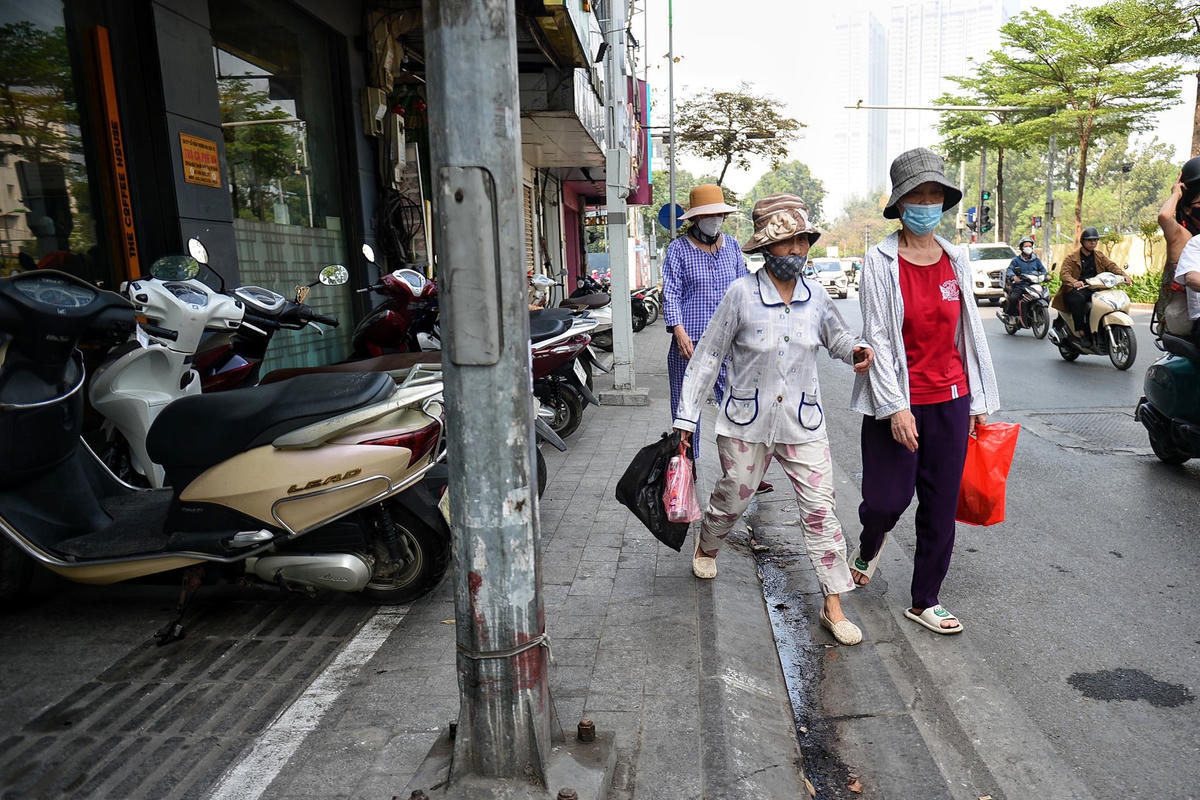 Chẳng thể di chuyển trên vỉa hè vì cột đèn, bốt điện người đi bộ buộc phải đi xuống lòng đường.
