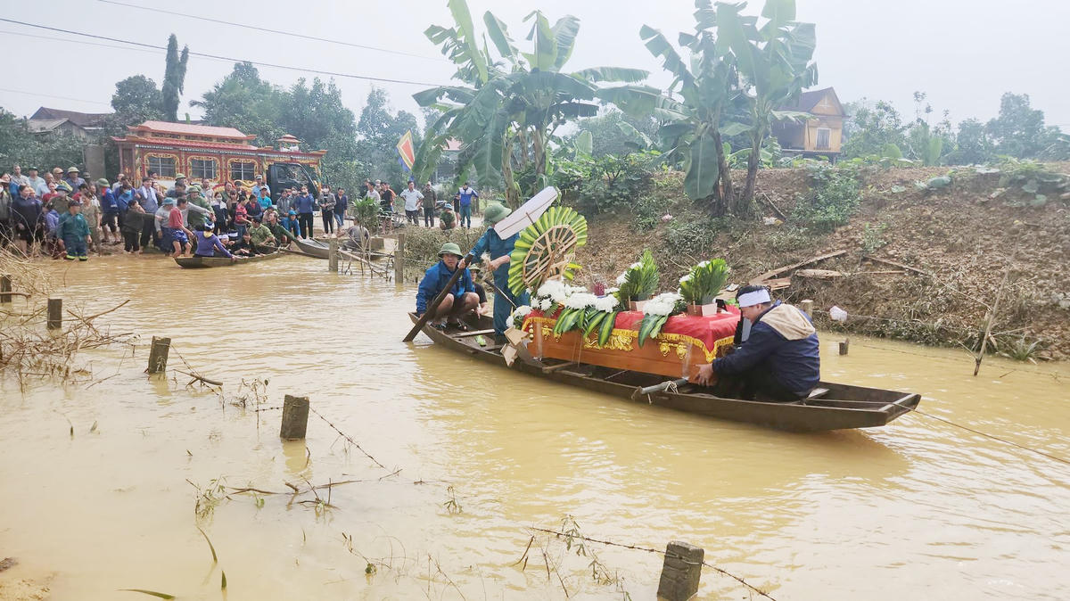 Người dân dùng thuyền chở quan tài em N.V.D. ra nghĩa trang.