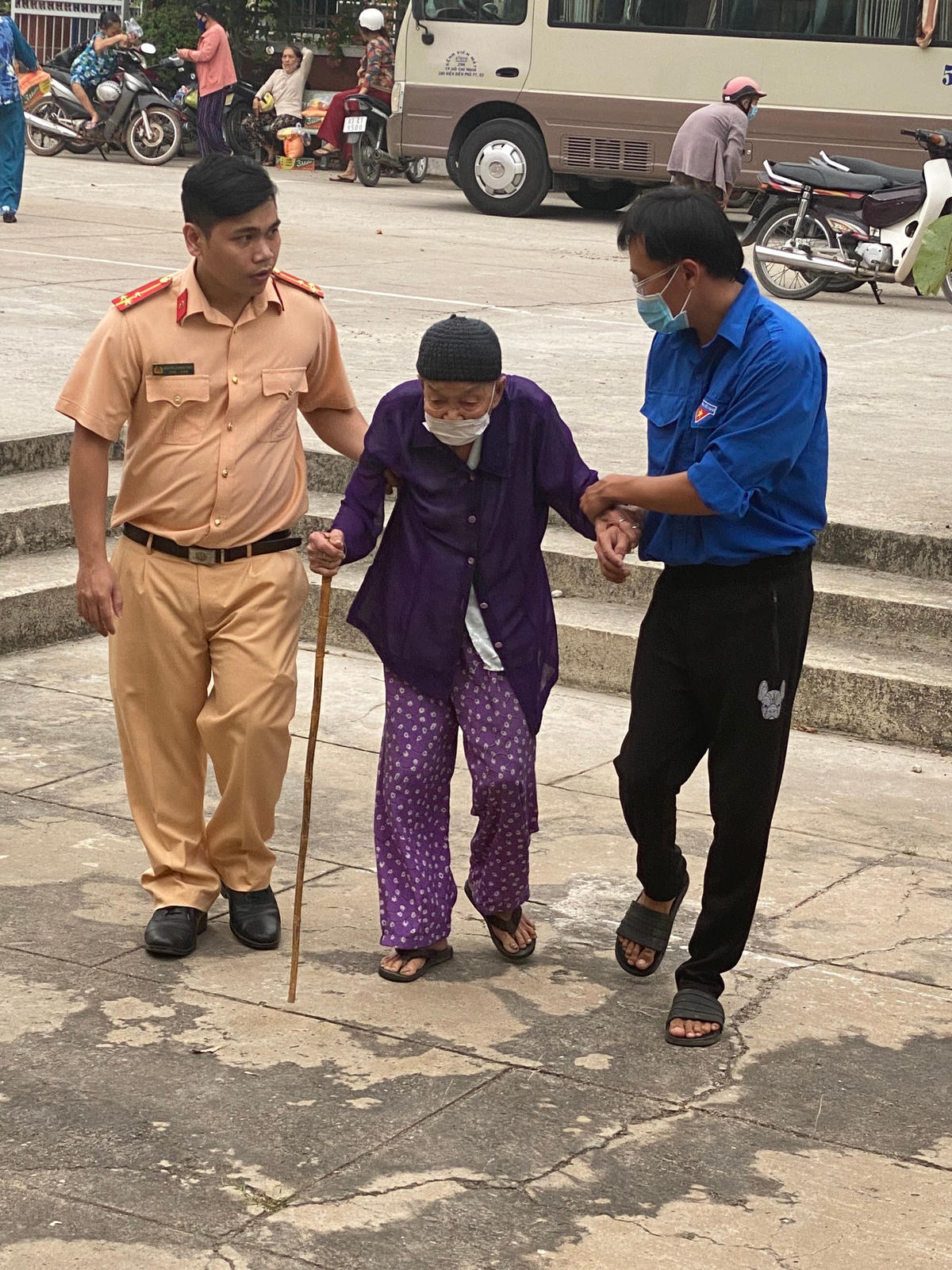 Một chiến sĩ CSGT và đoàn viên thanh niên huyện đoàn Củ Chi hỗ trợ một đại diện gia đình chính sách đến dự chương trình. (Ảnh: P.Ca).